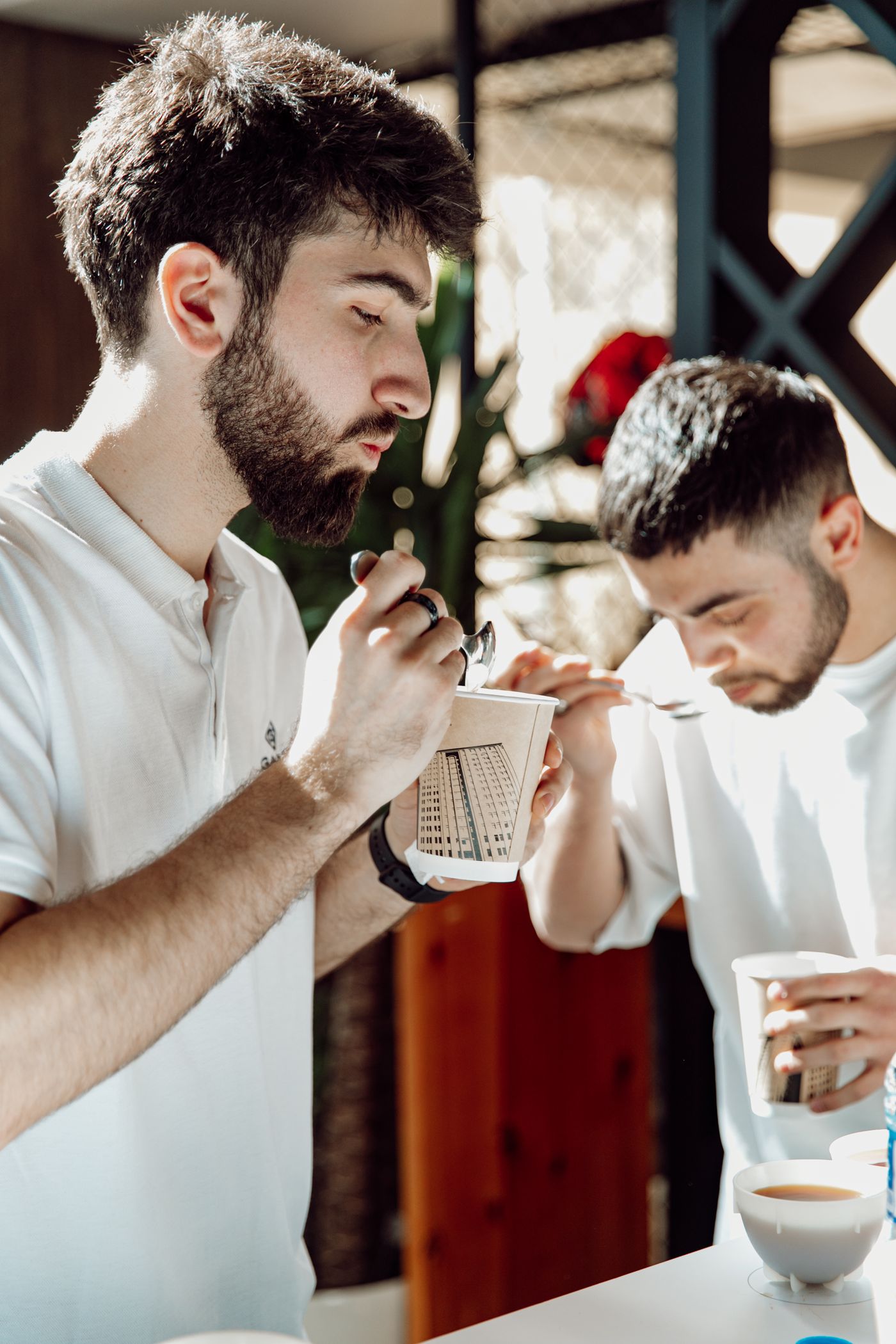 Twee mensen ruiken en proeven koffie tijdens een cupping